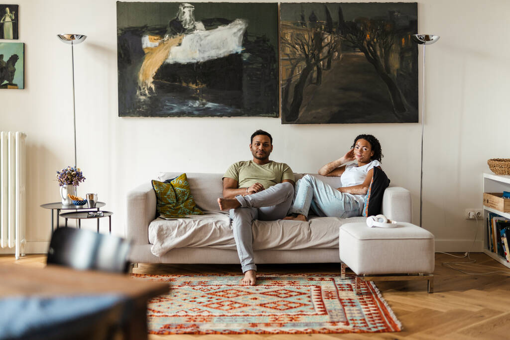 Bliskowschodni mężczyzna i kobieta odpoczywający na kanapie w domu - Zdjęcie, obraz