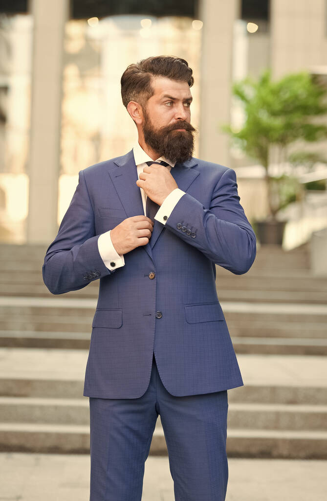 Komoly rendező hipster szakáll fix nyakkendő visel formális öltöny szabadban, formalwear - Fotó, kép