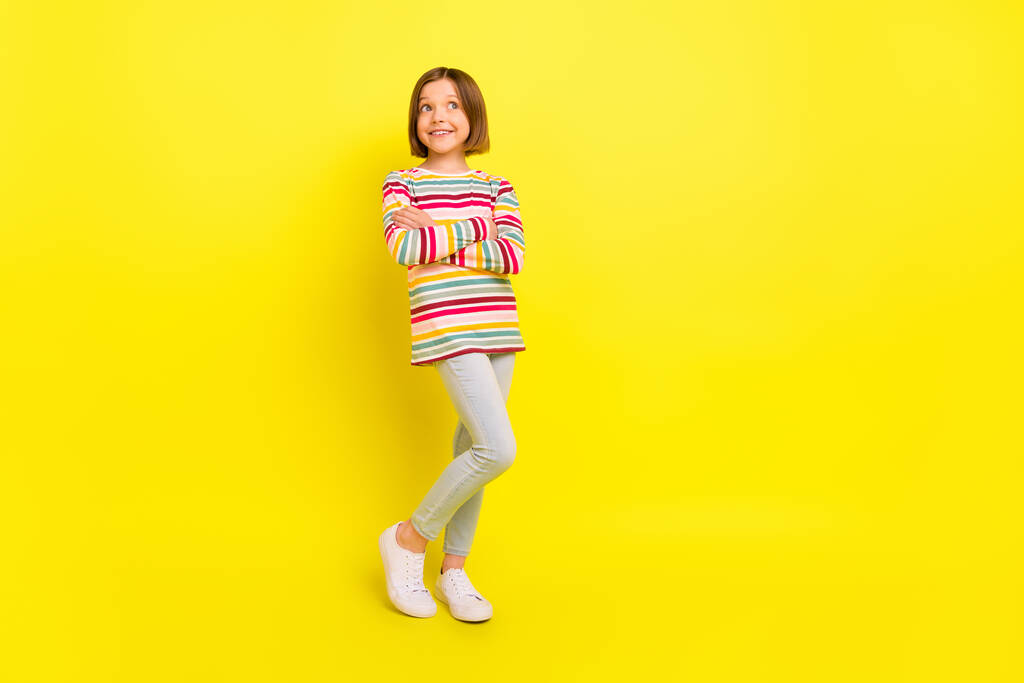 Pełna długość zdjęcie dość krótka fryzura mała dziewczyna skrzyżowane ramiona wyglądają puste miejsce nosić spodnie odizolowane na żółtym tle kolor - Zdjęcie, obraz