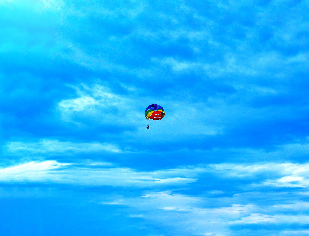 Két férfi egy színes és fényes ejtőernyőn hajózik a kék ég felé. Fénymásolási hely - Fotó, kép