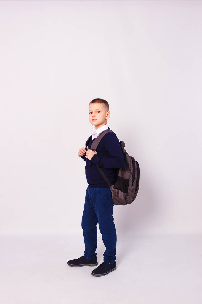 10-vuotias poika koulupuvussa reppu selässä valkoisella taustalla - Valokuva, kuva