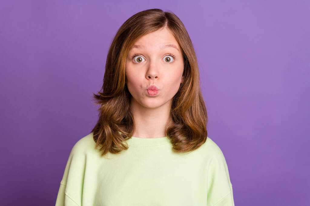 Kuva nuori tyttö hämmästynyt yllättynyt mökötti huulet lähettää ilman suudelma eristetty violetti väri tausta - Valokuva, kuva