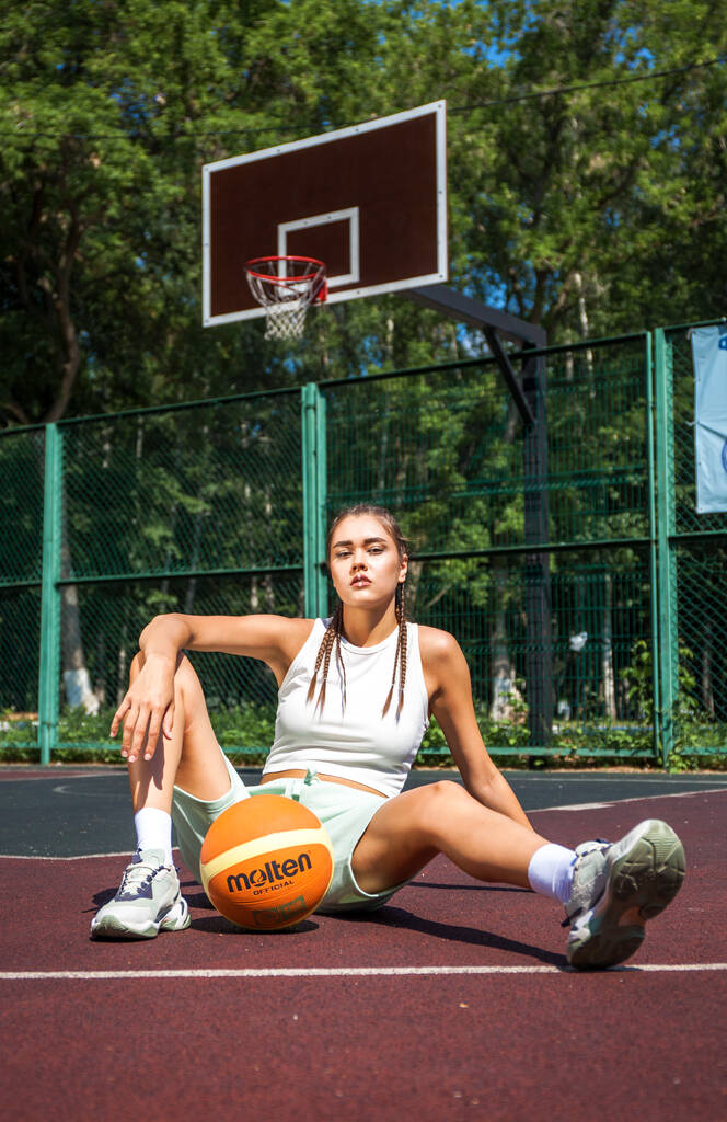 Jovem bela menina morena posando no campo de basquete - Foto, Imagem