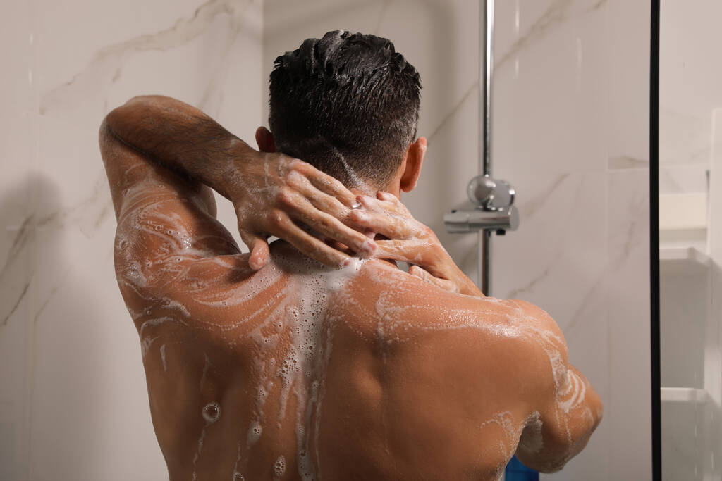 Мужчина принимает душ с гелем дома - Фото, изображение