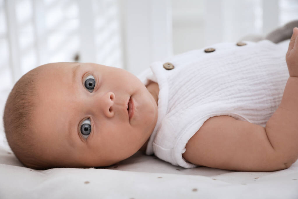 Cute little baby lying on bed at home, closeup - Photo, Image