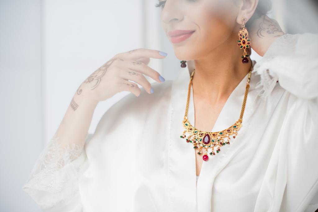 partial view of young indian bride wearing necklace on white - Photo, Image