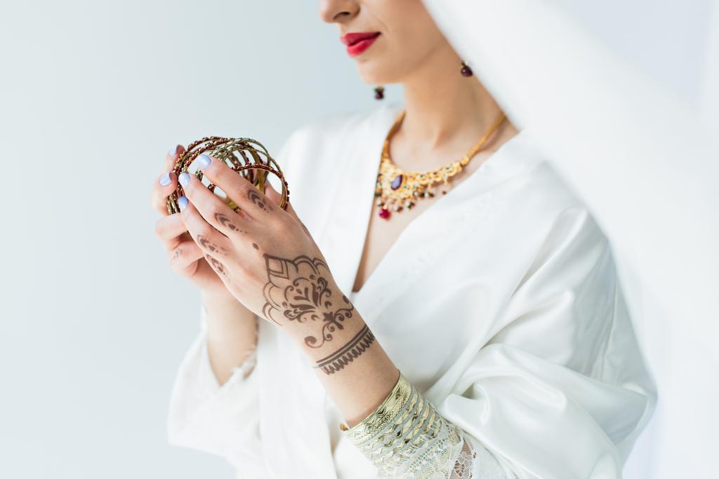 vista cortada de noiva indiana jovem segurando pulseiras em branco  - Foto, Imagem