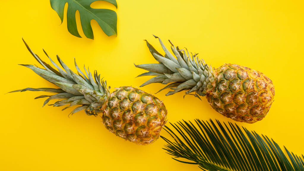 Ananas e foglie di palma su sfondo giallo estate colore. Tropicale estate ananas frutta piatto laici composizione. Banner web lungo - Foto, immagini