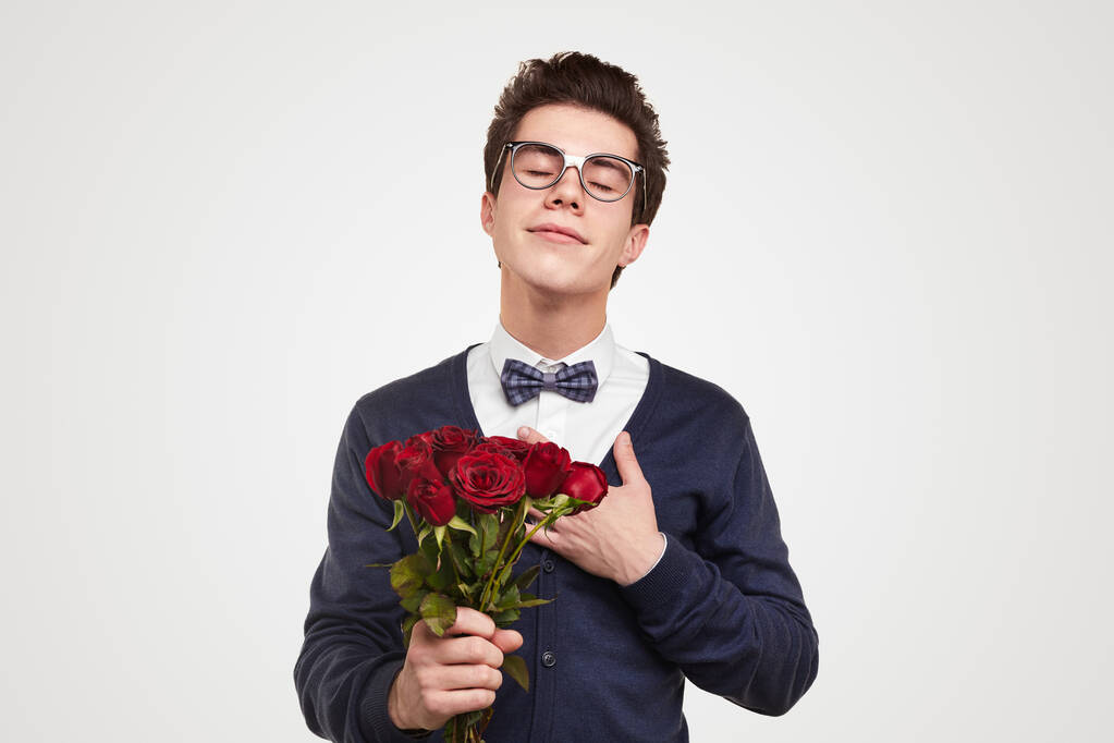 Молодий чоловік закоханий у букет з троянд
 - Фото, зображення