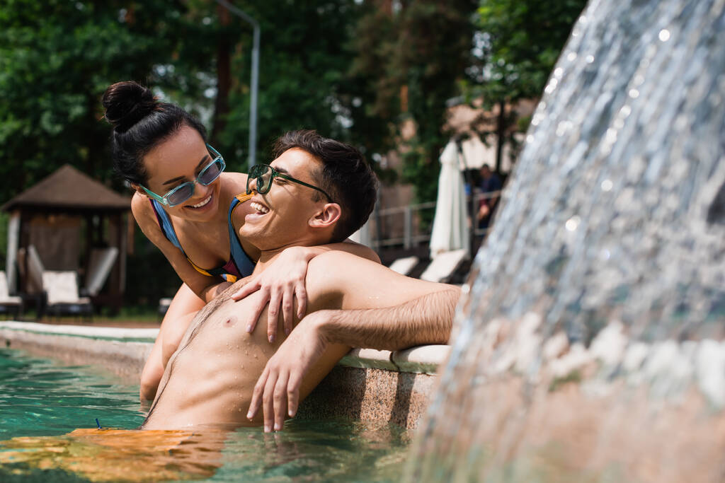 正のカップル過ごす時間近く噴水でスイミングプール  - 写真・画像