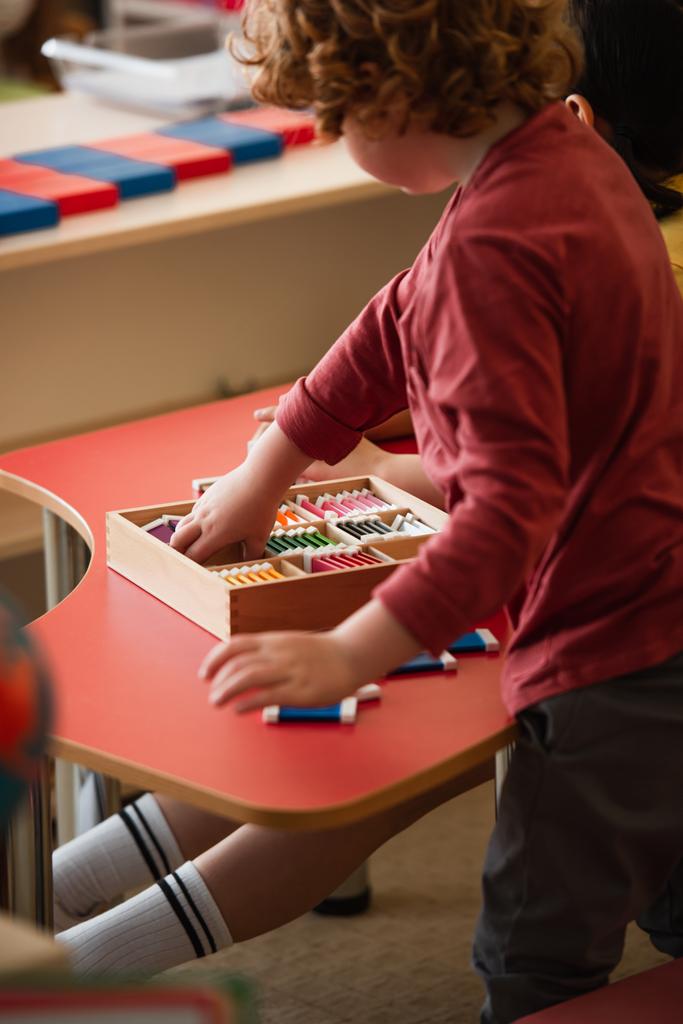részleges kilátás fiú játszik kognitív játék közelében lány Montessori iskolában - Fotó, kép