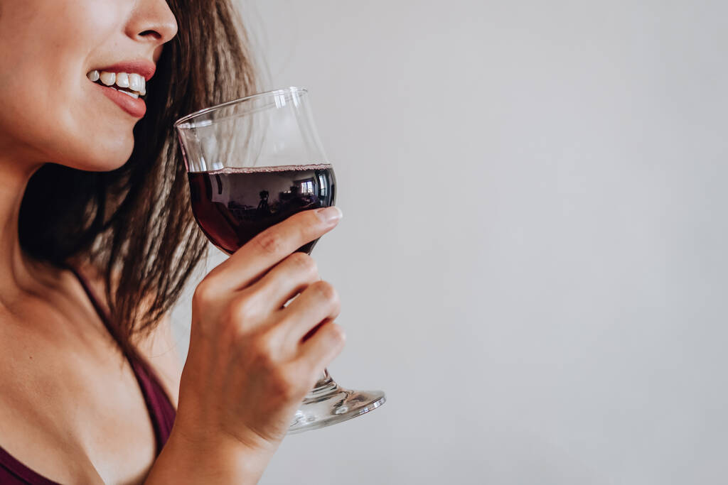 Ασιάτισσα γυναίκα πίνει κρασί στο σπίτι. επιλεκτική εστίαση - Φωτογραφία, εικόνα
