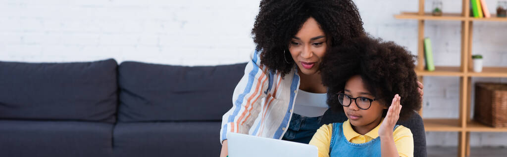 Madre y niño afroamericanos mirando el ordenador portátil en casa, pancarta  - Foto, imagen