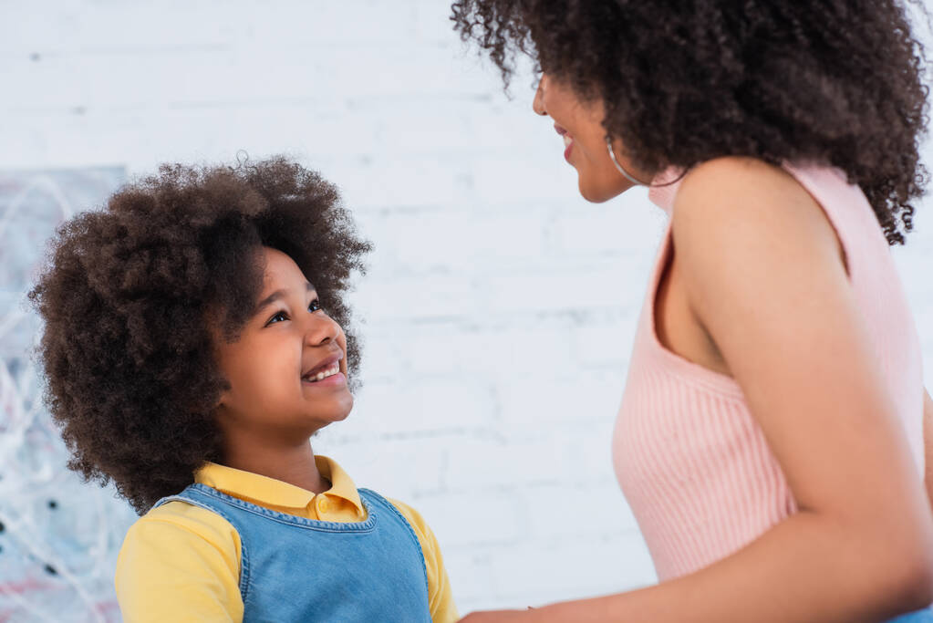 Sourire enfant afro-américain regardant parent à la maison  - Photo, image