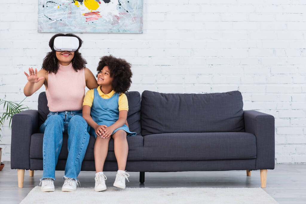 African american daughter looking at mother gaming in vr headset  - Photo, Image