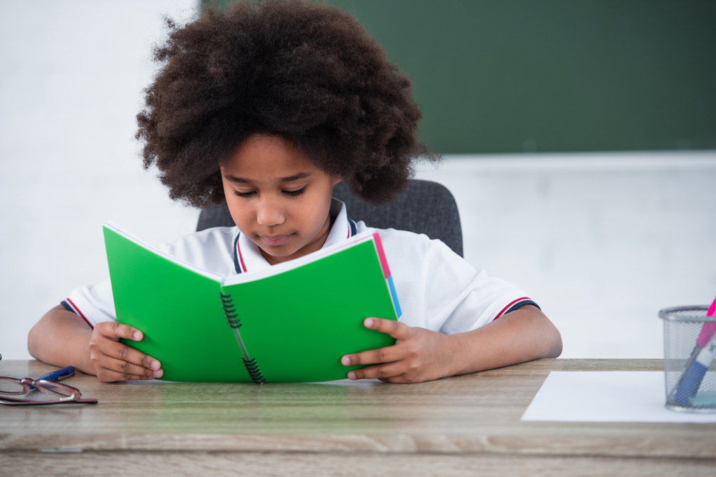 Afrikai-amerikai iskolás lány nézi notebook az osztályteremben  - Fotó, kép