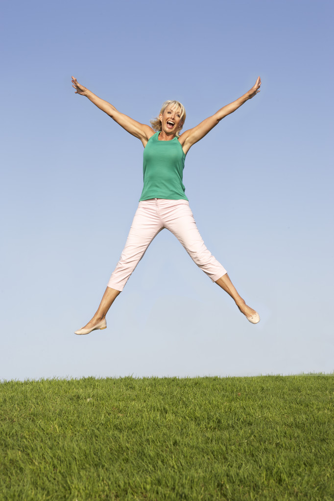 Senior vrouw springen in de lucht - Foto, afbeelding