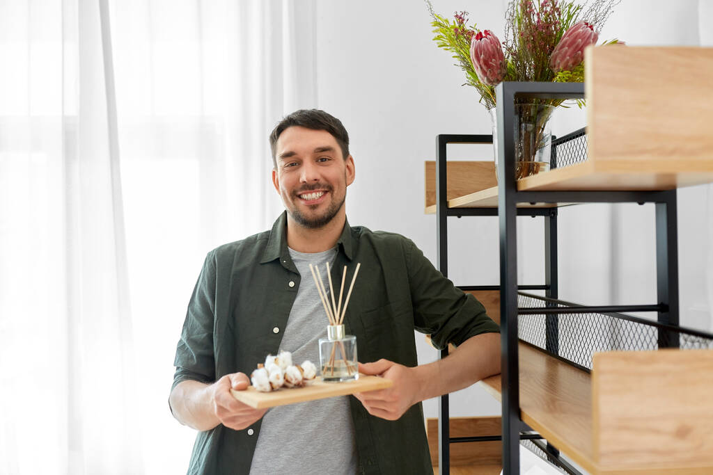 man placing aroma reed diffuser to shelf home - Photo, Image