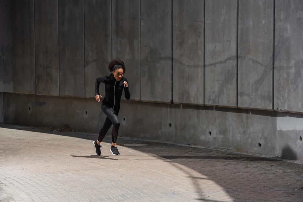 African american runner exercising near building outdoors  - Photo, Image