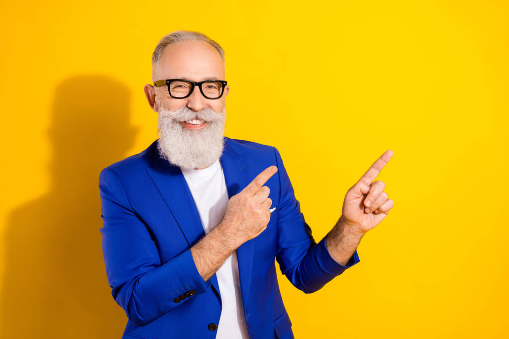 Foto di attraente giovane felice affascinante uomo punta il dito vuoto spazio sorriso isolato su sfondo di colore giallo - Foto, immagini