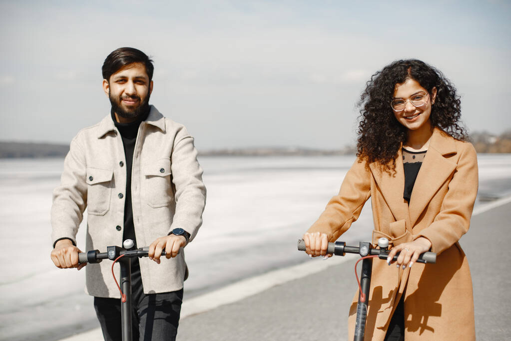 Interracial jovem casal com scooters no fundo da cidade - Foto, Imagem