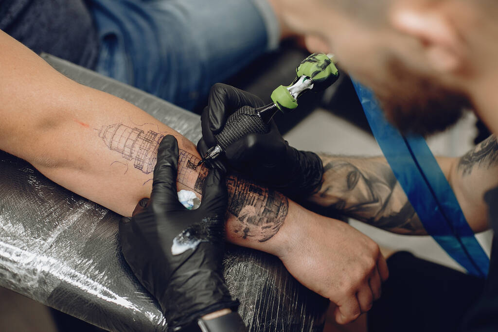Man doet een tattoo in een tattoo salon - Foto, afbeelding