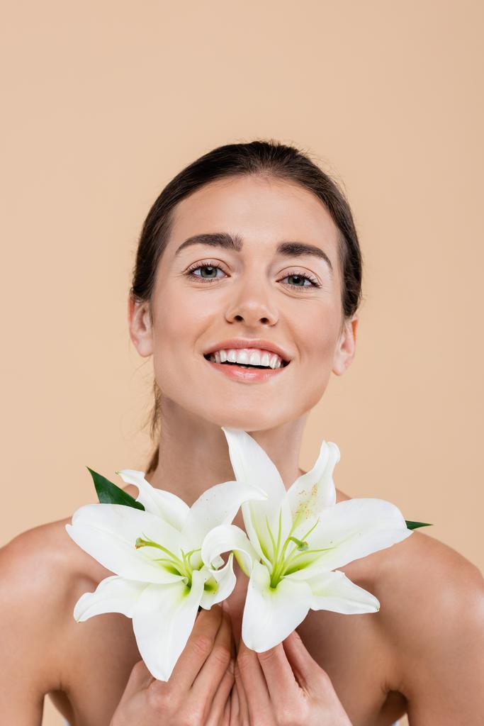 happy woman with lily flowers looking at camera isolated on beige, beauty concept - Photo, Image