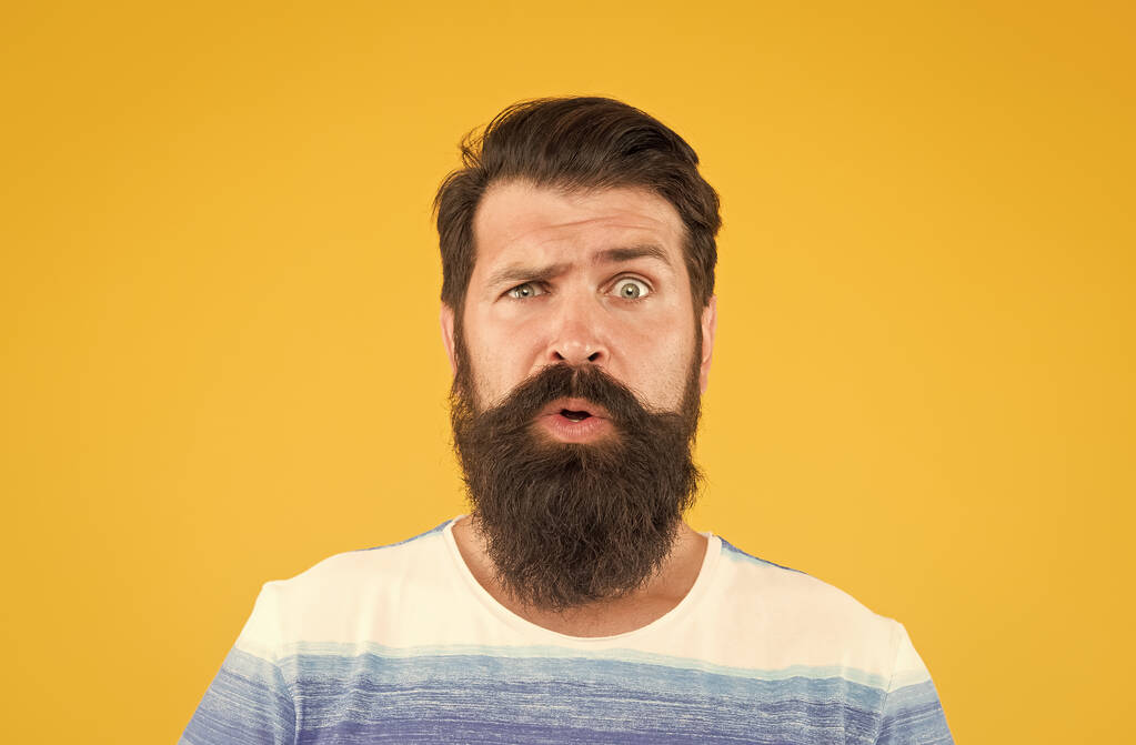 Hair care and skincare. amazed brutal bearded man on yellow backdrop. handsome confident man has perfect hairdo. male facial care. portrait of brutal bearded man. serious stylish man with moustache - Photo, Image