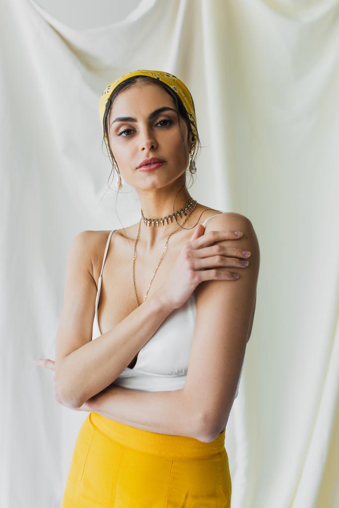 woman in yellow headscarf and crop top posing on white - Photo, Image