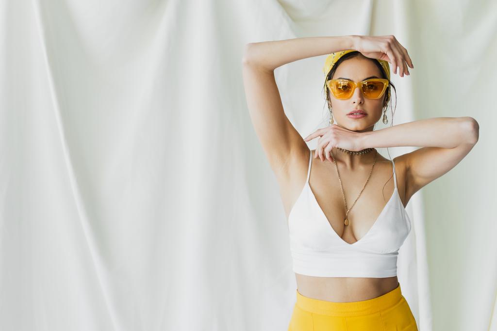 pretty woman in yellow sunglasses and headscarf posing on white  - Photo, Image