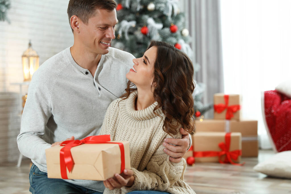 Glückliches Paar mit Weihnachtsgeschenk zu Hause - Foto, Bild