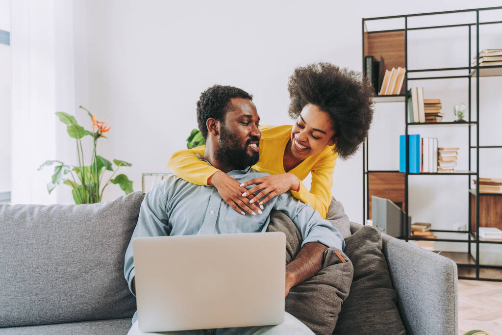 Bilgisayar dizüstü bilgisayarı üzerinde çalışan güzel Afro-Amerikalı çift modern çiftler online alışveriş yapıyor. - Fotoğraf, Görsel
