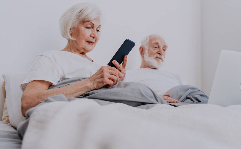 Piękna para seniorów ciesząca się czasem spędzonym razem w domu - Moderowa para starsza surfuje po Internecie na laptopie - Zdjęcie, obraz