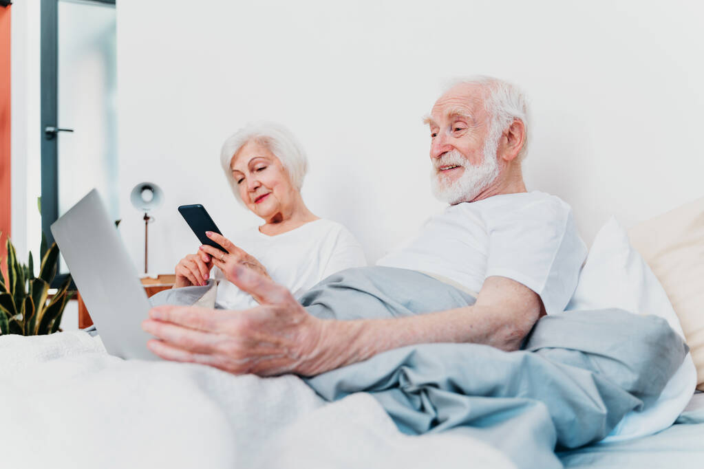 Hermosa pareja de ancianos disfrutando de tiempo juntos en casa - Moder pareja de ancianos navegar por Internet en el ordenador portátil - Foto, imagen