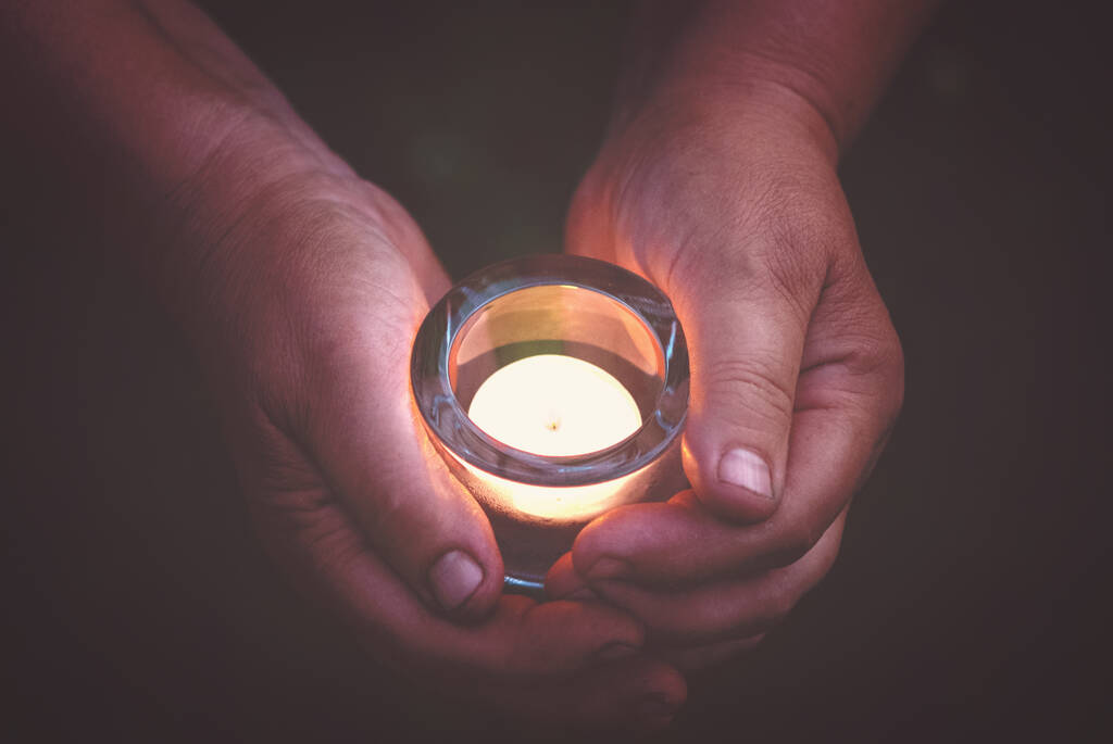 ręce trzymające płonącą świecę w mroku, modlitwie i koncepcji duchowości - Zdjęcie, obraz