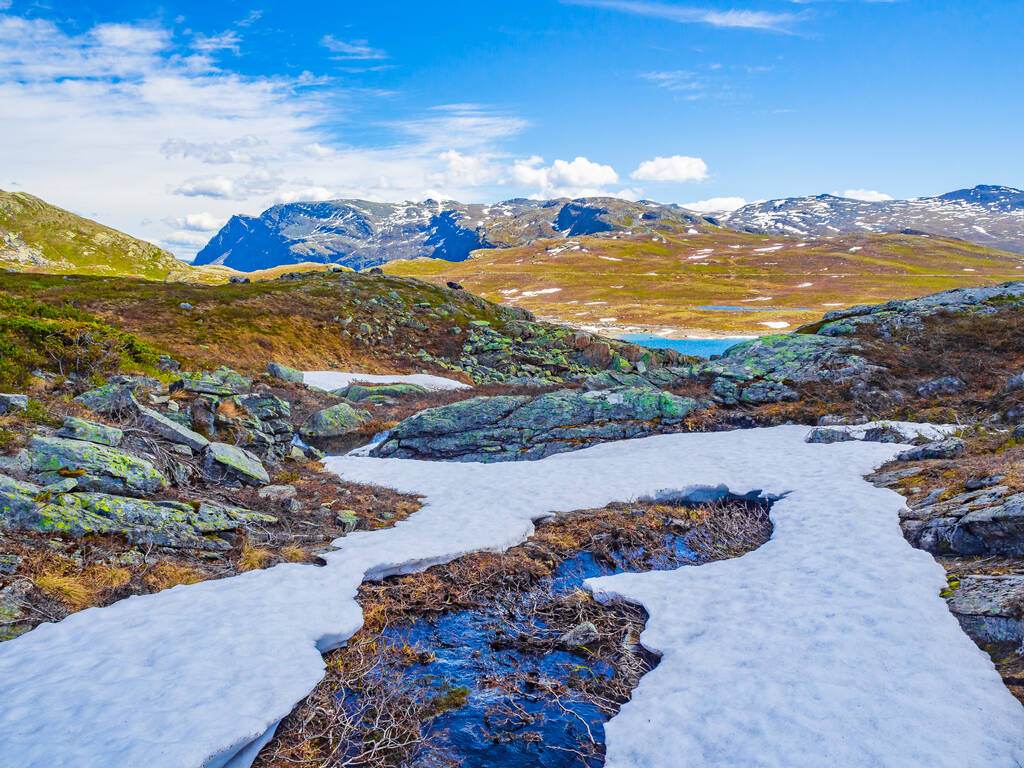 Amazing Vavatn Lake panorama ruw landschap uitzicht rotsen rotsblokken en bergen met sneeuw tijdens de zomer in Hemsedal Noorwegen. - Foto, afbeelding