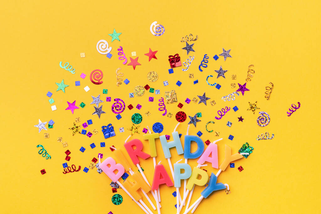 feestachtergrond met tekst Happy Birthday van kleurrijke kaarsen met confetti op oranje achtergrond. Gelukkige verjaardag of feest wenskaart. Flat lay decoratie party concept bovenaanzicht - Foto, afbeelding