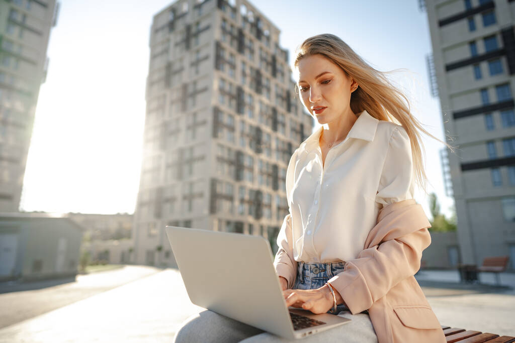 Молода успішна бізнес-леді використовує ноутбук для роботи на відкритому повітрі
 - Фото, зображення