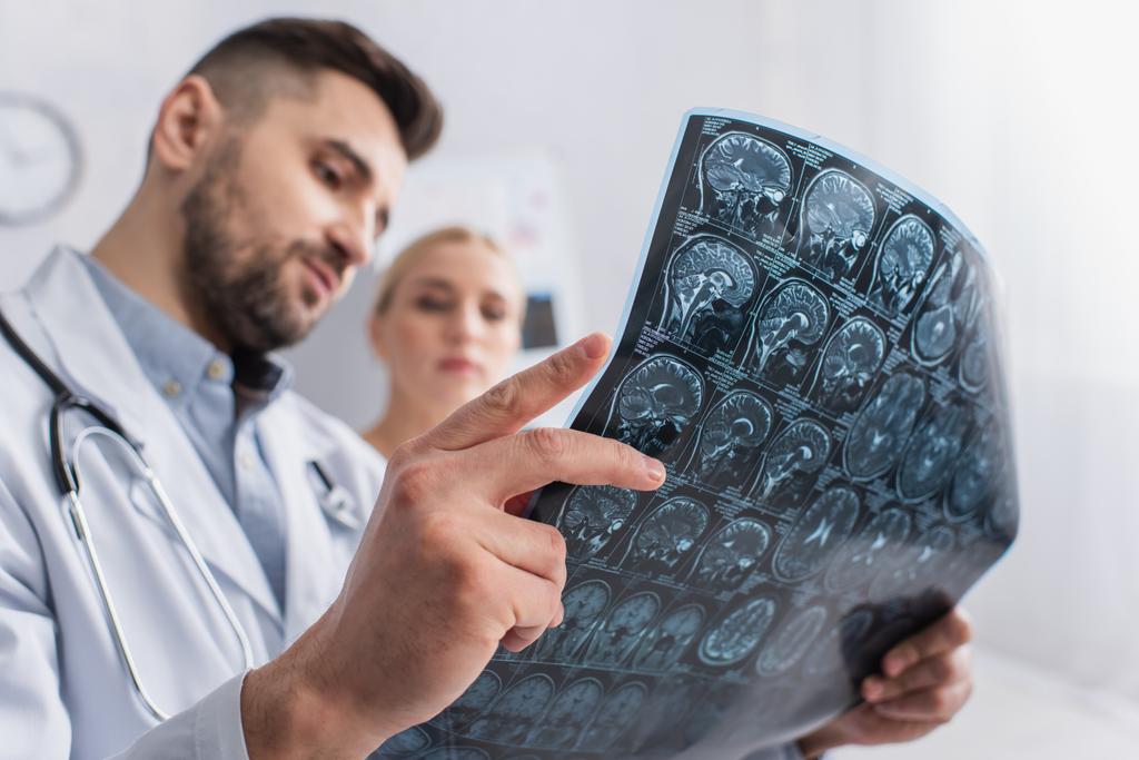 розмитий лікар і пацієнт, дивлячись на сканування мозку в лікарні
 - Фото, зображення