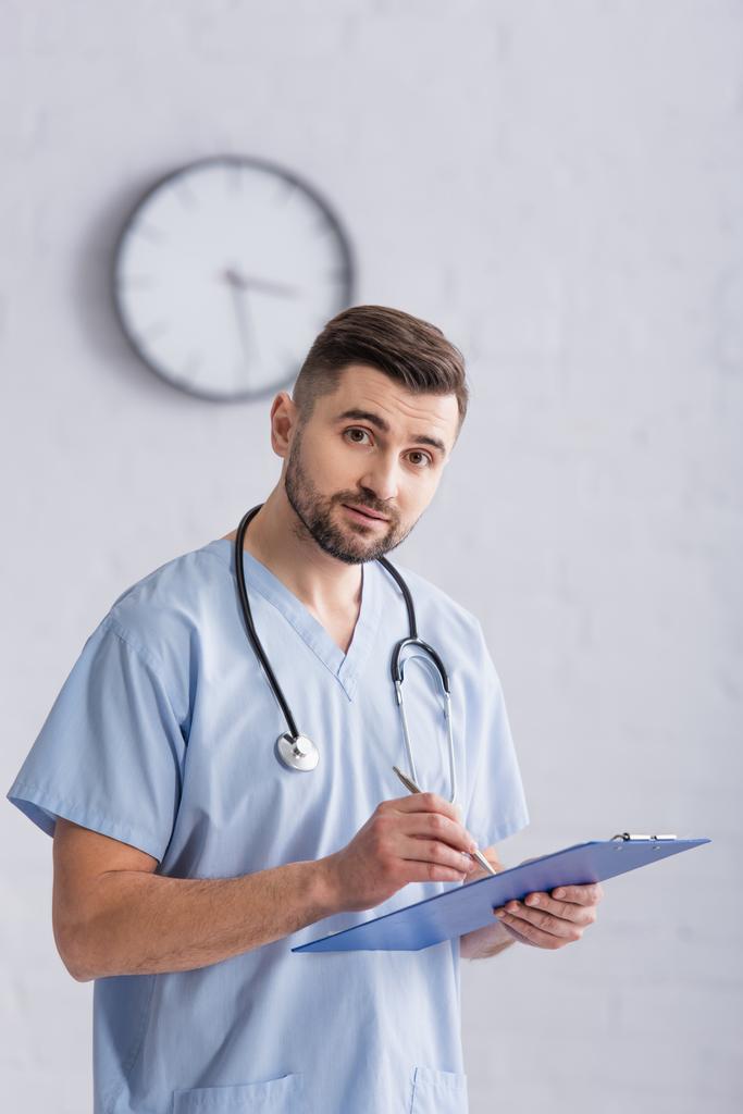 Doctor With Clipboard Looking At Camera In Free Stock Photo and Image