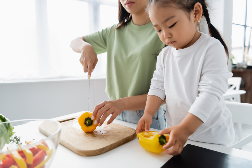 アジア系の母親と子供がキッチンでサラダを作る  - 写真・画像
