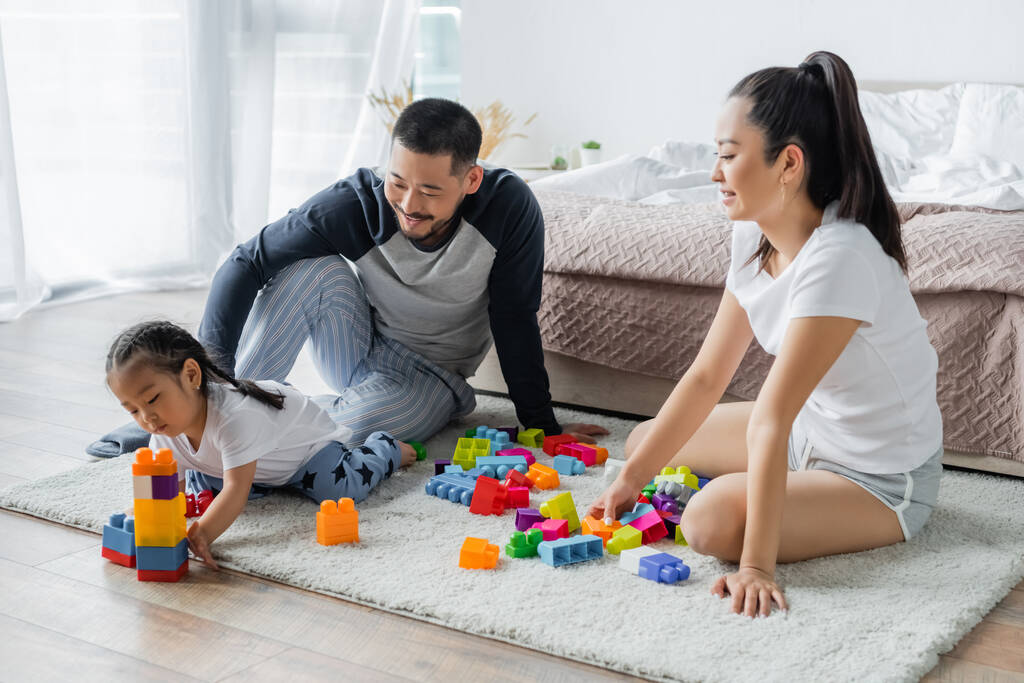 felice asiatico genitori guardando toddler figlia giocare building blocks  - Foto, immagini