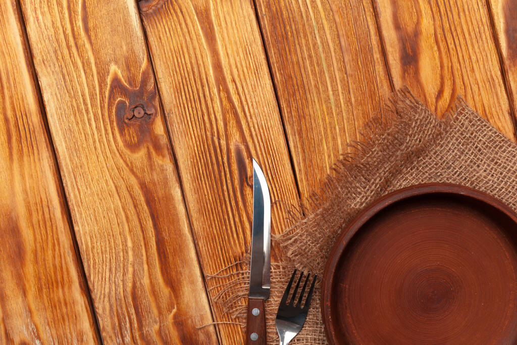 Empty plate and towel over wooden table background. - Photo, Image