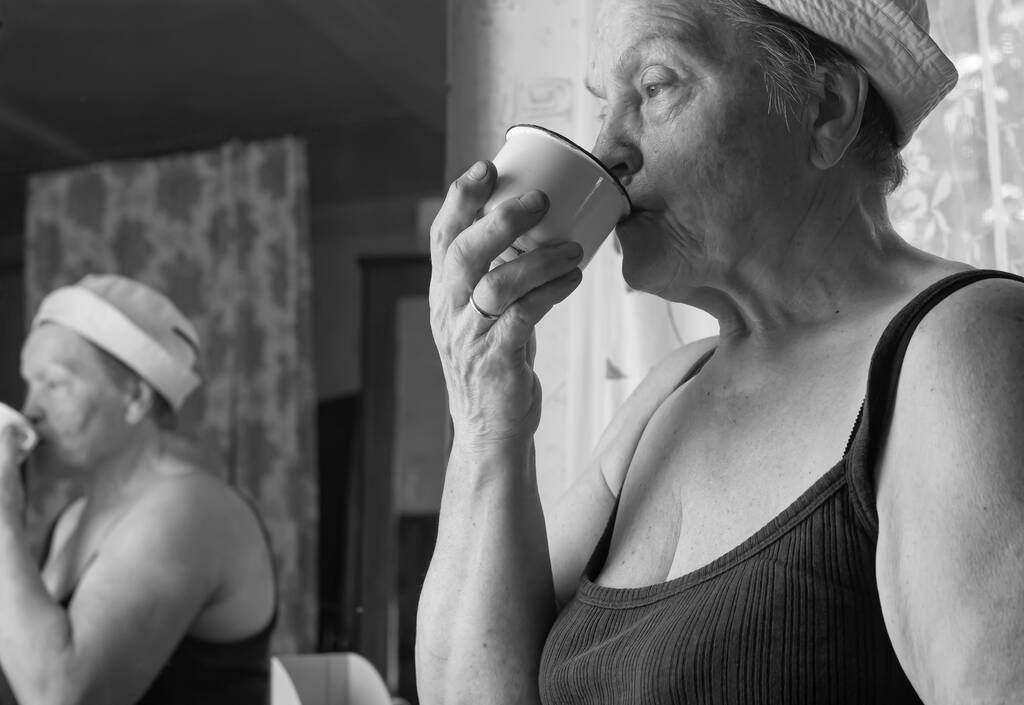 Black and white portrait of tired mature real female farm worker drinking water from cup - Photo, Image