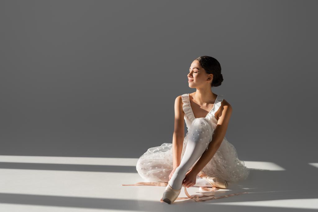 Side view of ballerina wearing pointe shoe on grey background  - Photo, Image