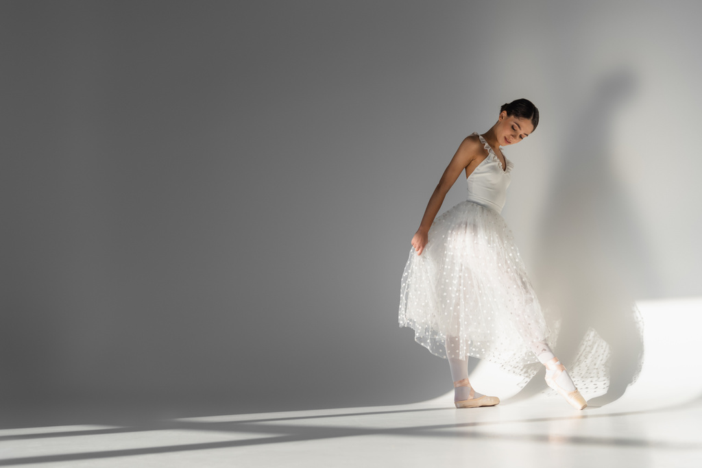 Ballerina tarkastellaan osoitinkenkä harmaalla taustalla  - Valokuva, kuva