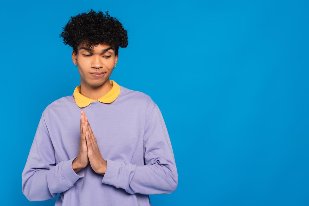  shamed african american man standing with praying hands gesture isolated on blue - Photo, image