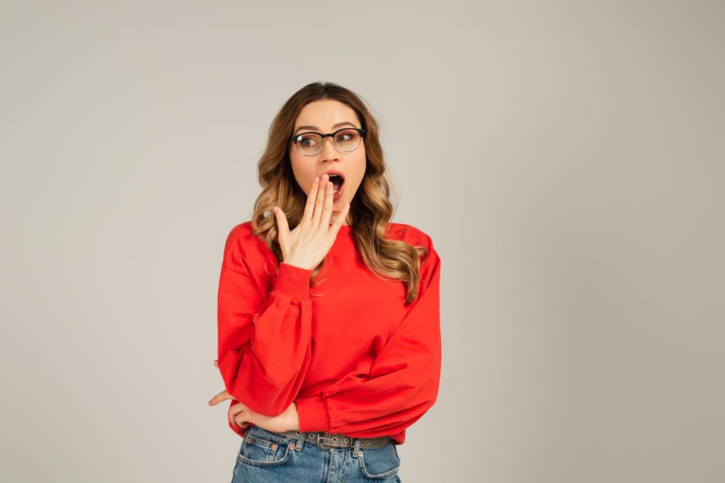 σοκαρισμένη γυναίκα σε γυαλιά με ανοιχτό στόμα απομονώνονται σε γκρι - Φωτογραφία, εικόνα