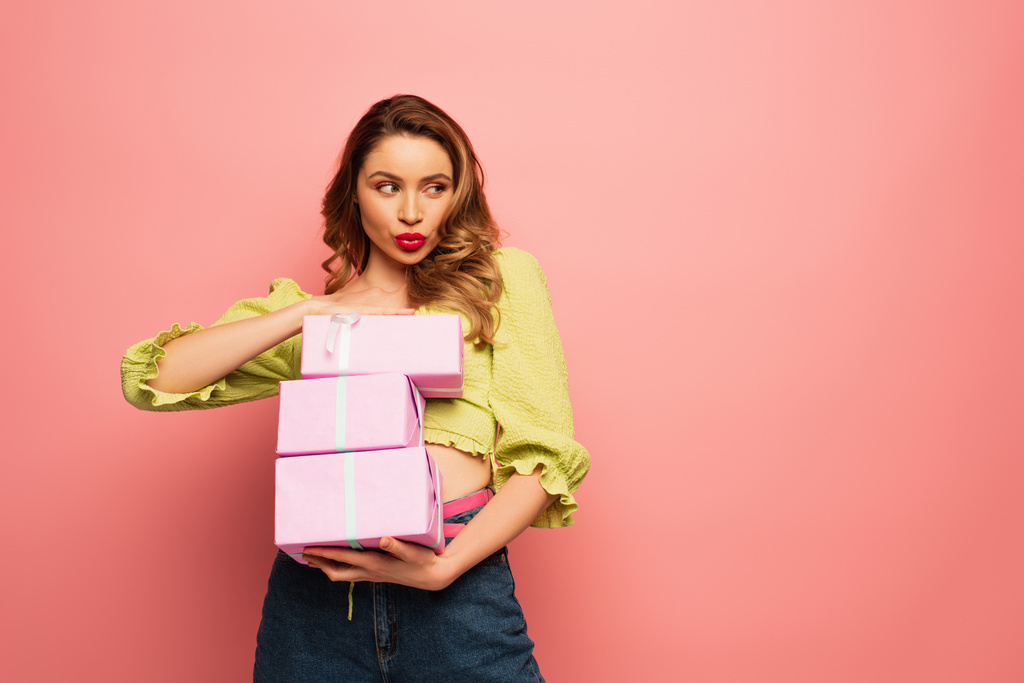 mulher com rosto de pato segurando caixas de presente embrulhado isolado em rosa - Foto, Imagem