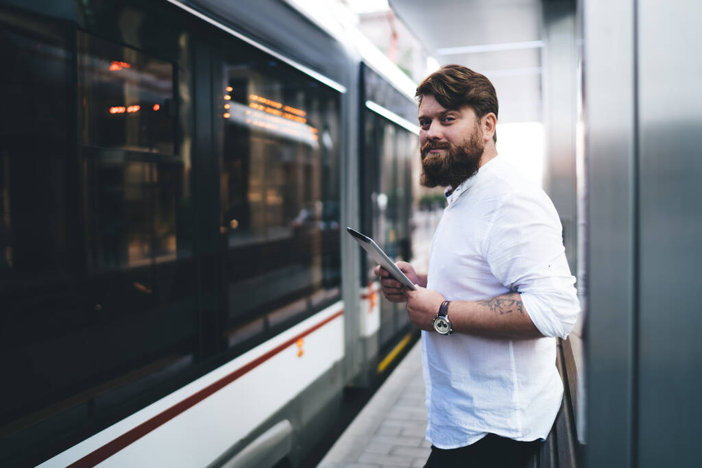 近代的な駅でバスを待っているとカメラを見て白いシャツに身を包んだ男性管理者のサイドビュー - 写真・画像
